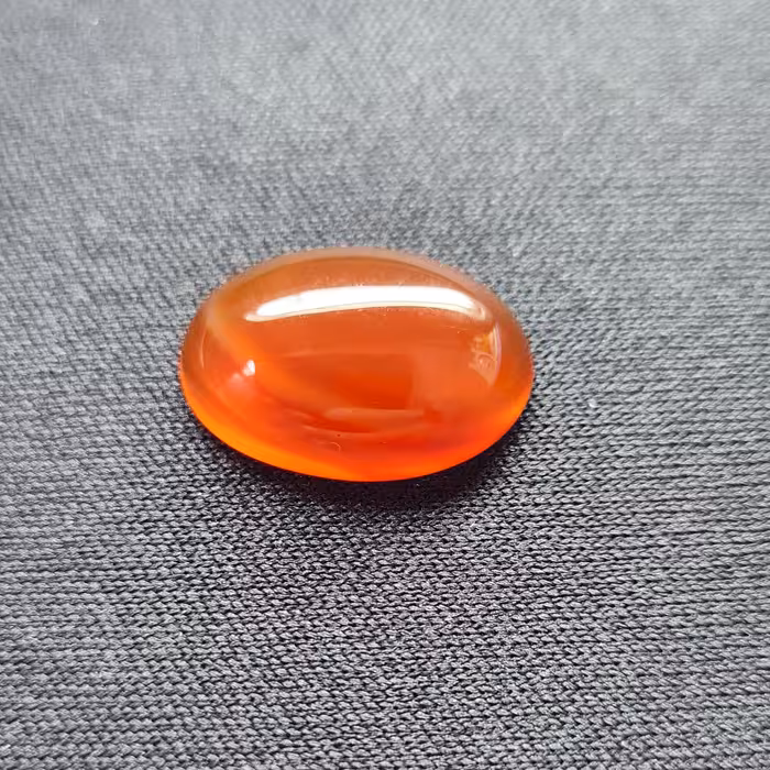 نگین عقیق قرمز (مشخصات: طول: 1.8 سانتی متر. عرض:  1.3 سانتی متر. ارتفاع: 0.45 سانتی متر.)