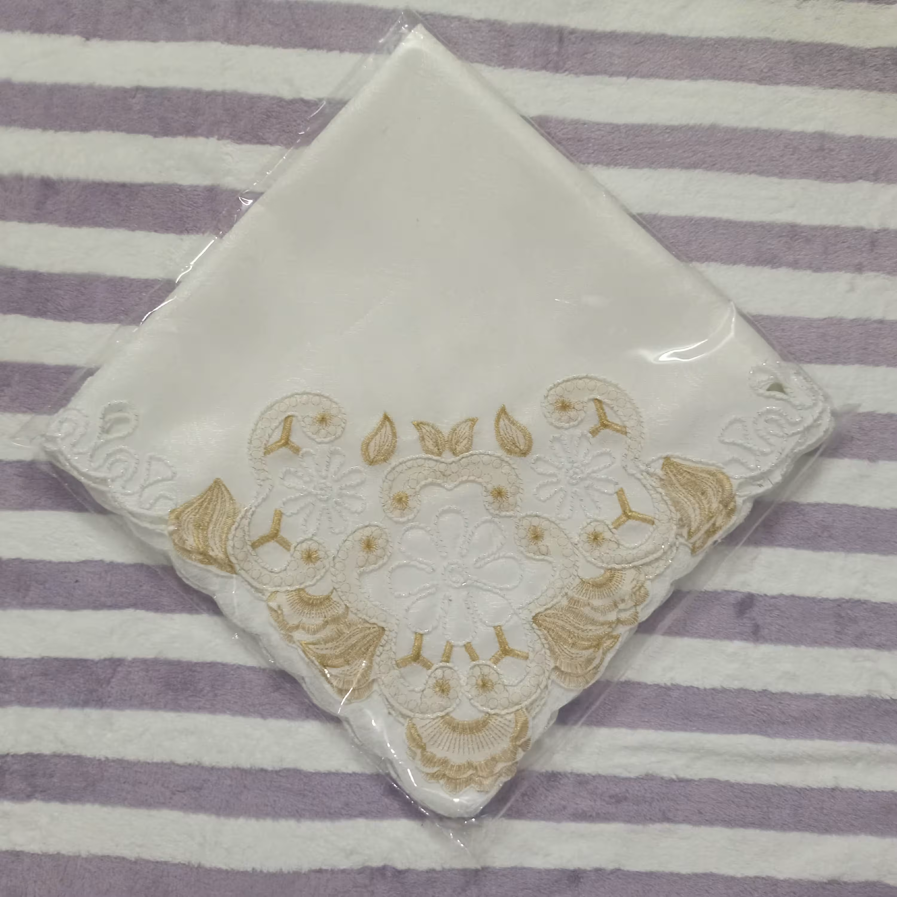 رومیزی ترمه سفید رنگ با حاشیه گل های طلایی و نقره ای گلدوزی شده در ابعاد 60در60سانتیمتری