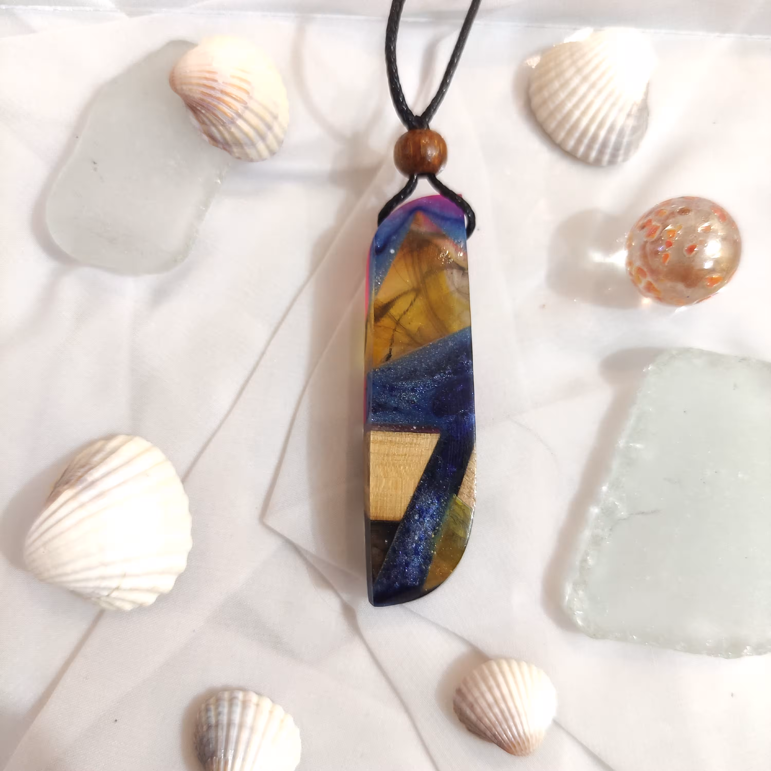 گردنبند رزین و چوب گردو
طرح تلفیقی اسموک(دود) و اوشن(اقیانوس)
رنگ زرد و سرمه ای و صورتی
کد 14