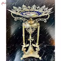 کنار سالنی طرح سه فرشته بالدار، با بدنه برنزی و بشقاب چینی