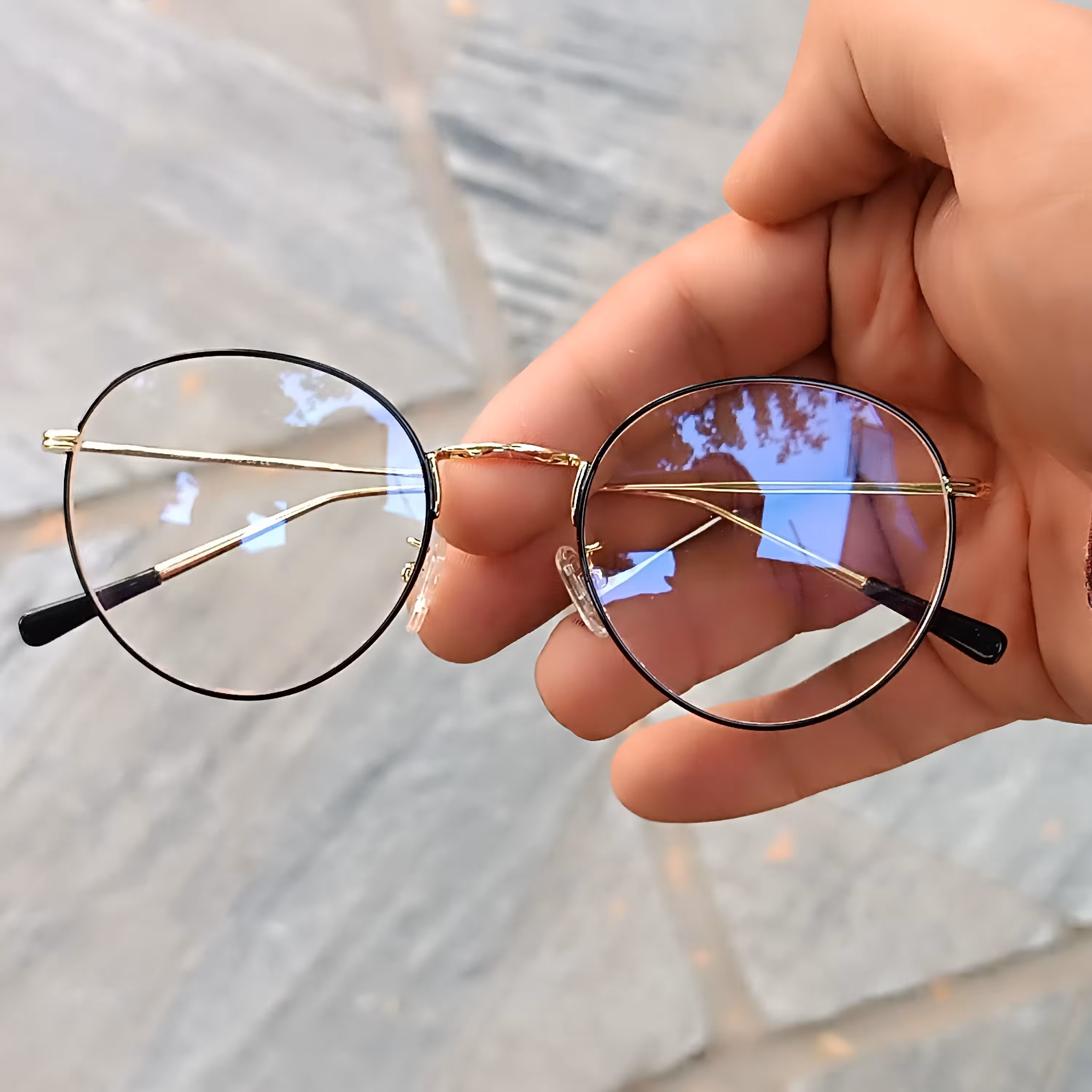 عینک طبی گرد بدون نمره قابلیت ساخت عدسی های طبی را دارد همراه با جلد و دستمال رنگ طلایی دور حدقه مشکی 