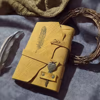 دفتر چرمی پر ، 19 در 14 ، چرم هورس بزی زرد مات، صد برگ کاغذ نخودی بدون خط ،حکاکی پر ، با بست فلزی کلید