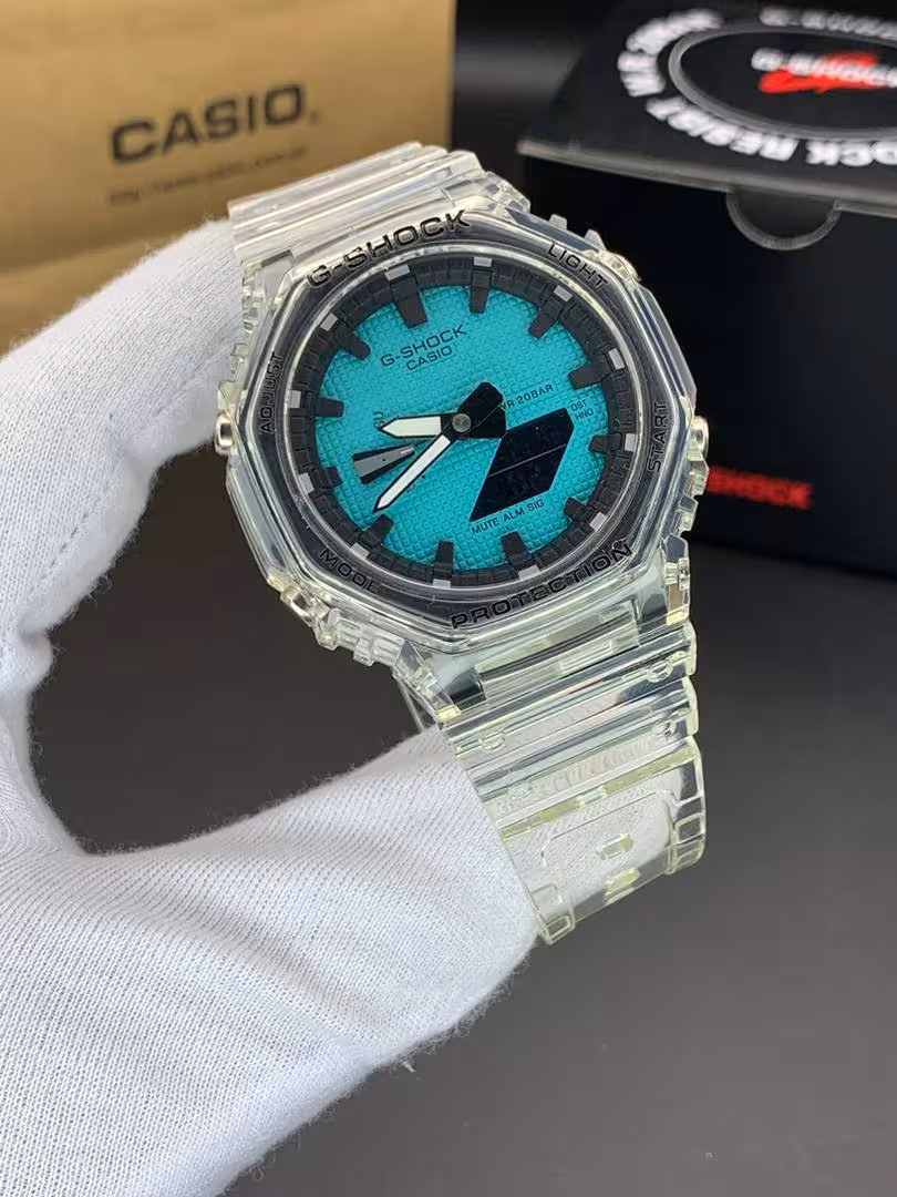 ساعت مچی کاسیو جیشاک مدل GA-2100 صفحه آبی فیروزه ای دور مشکی بند شفاف