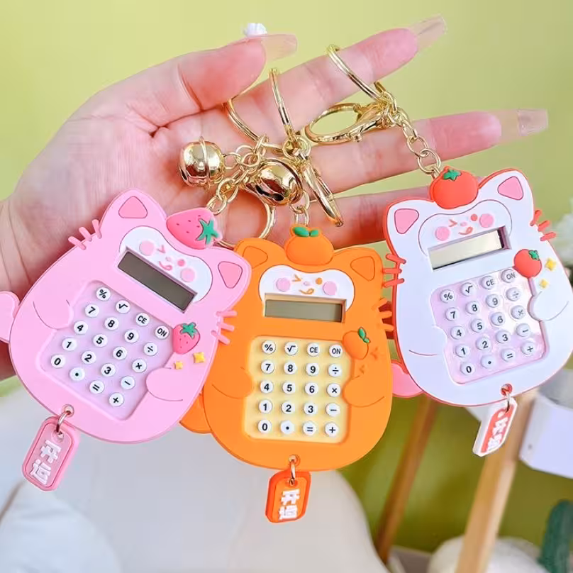 ماشین حساب فانتزی و بازی و آویز کیف و جاکلیدی فانتزی گربه در رنگ های صورتی سفید نارنجی