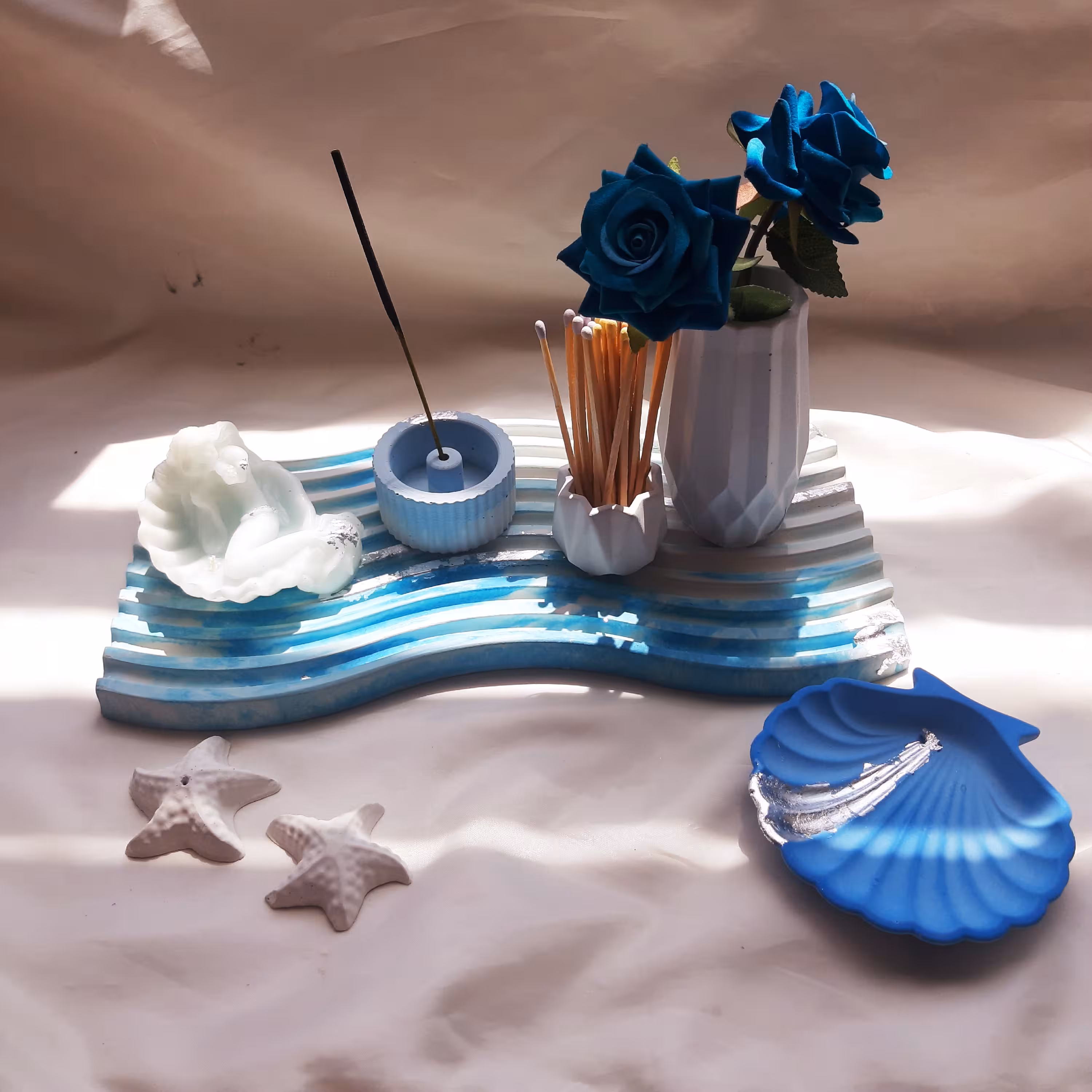 ست شمع و دکوری بتنی آبی کار شده با ورق نقره ست شامل استند موج شمع پری دریایی جاعودی جاکبریتی گلدان و صدف