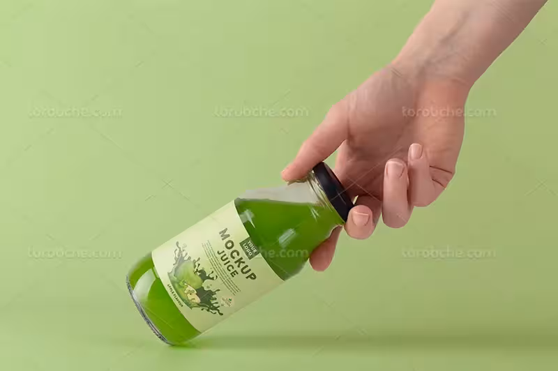موکاپ بطری آبمیوه در دست برای طراحی | گرافیک با طعم تربچه