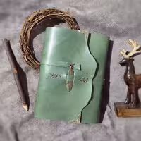 دفتر چرمی ، چرم گاوی سبز زیتونی براق، 20 در 15, صد برگ کاغذ نخودی رنگ خطدار ، بند و بست پر فلزی