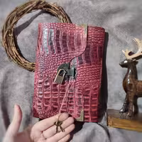 دفتر قفلدار کروکو، چرم گاوی افکتی قرمز ، 19 در 14 سانت ، صد برگ کاغذ نخودی رنگ ، قفلدار