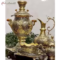 سرویس سماور ذغالی برنجی با ظرفیت 4.5 لیتر، دارای روکش محافظ و تنوره، با قلم‌زنی طرح اسلیمی