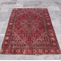 فرش دست بافت زنجان کد 39134 با الیاف طبیعی، طرح لچک و ترنج، زمینه لاکی و حاشیه سرمه ای