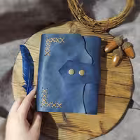 کلاسور چرمی ، چرم گاوی افکتی کریزی رنگ سورمه ای ، ابعاد 17 در 12 ، به همراه صد برگ کاغذ خطدار ،یک جیب و جای کارت، دو ورقه چرمی برای زیر و روی کاغذها