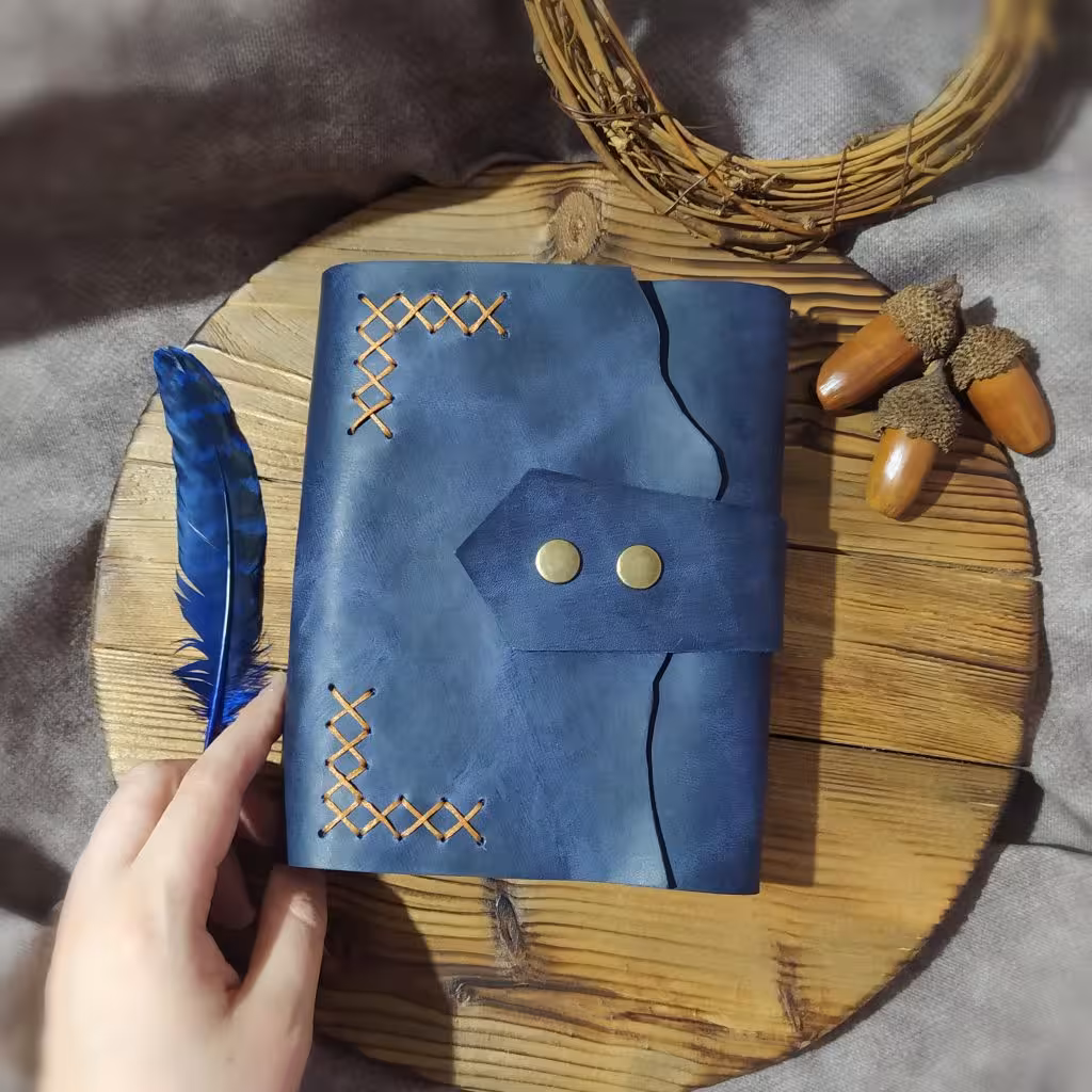 کلاسور چرمی ، چرم گاوی افکتی کریزی رنگ سورمه ای ، ابعاد 17 در 12 ، به همراه صد برگ کاغذ خطدار ،یک جیب و جای کارت، دو ورقه چرمی برای زیر و روی کاغذها