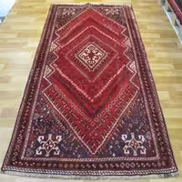 فرش دستباف شیراز ترکباف طرح لچک و ترنج، رنگ زمینه لاکی، رنگ حاشیه قهوه‌ای، کد 39801