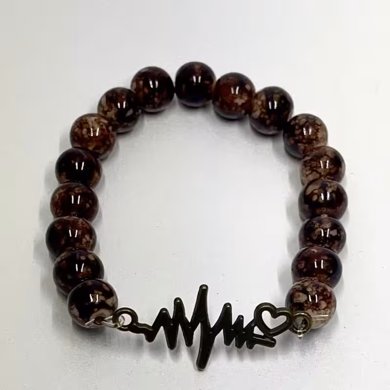 دستبند مدل کشی با مهره های آبرنگی رنگ قهوه ایی و خرج کار برنزی طرح ضربان قلب