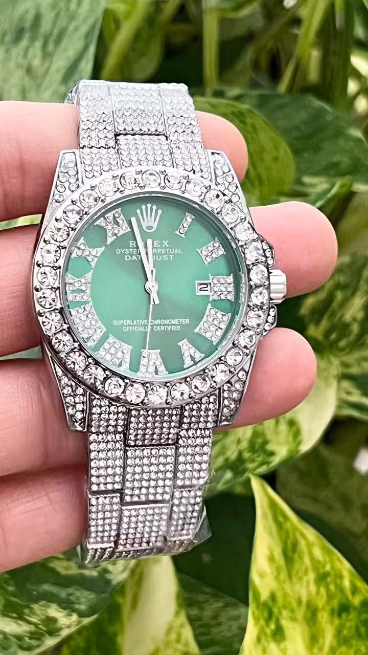 ساعت مچی زنانه یا دخترانه رنگ نقره ای صفحه سبز  دارای روزشمار قاب و بند فول نگین  بند استیل  و قفل استیل فشاری   دارای جعبه کادویی بالشتک دار  شش ماه گارانتی موتور   شیشه کریستال تلسکوپی ضدخش  نگین مخراج کاری شده کاملا سفت و محکم