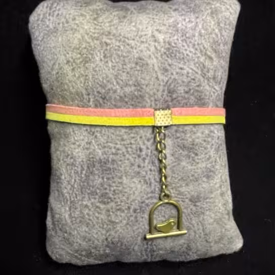 دستبند تریشه چرمی مدل ساده زرد و صورتی کم رنگ با زنجیر و خرج کار برنزی مرغ آمین و تاج