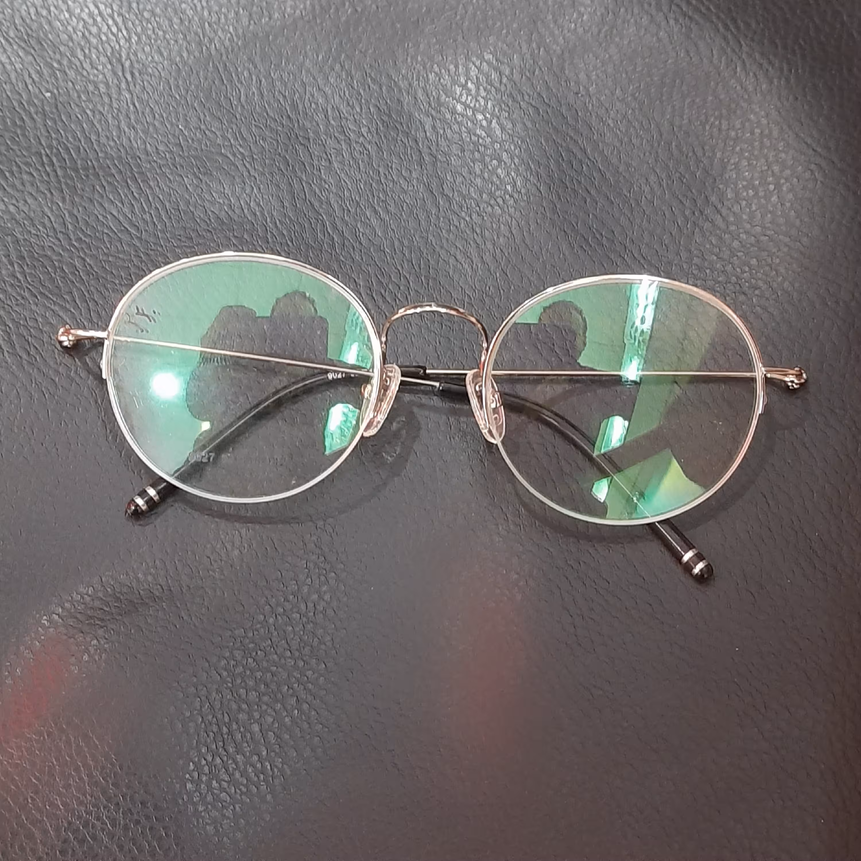 عینک طبی  گرد نیمه قاب فلزی بسیار ظریف با قابلیت تعویض عدسی های طبی نمره دار رنگ نقره ای  همراه با جلد و دستمال عینک 