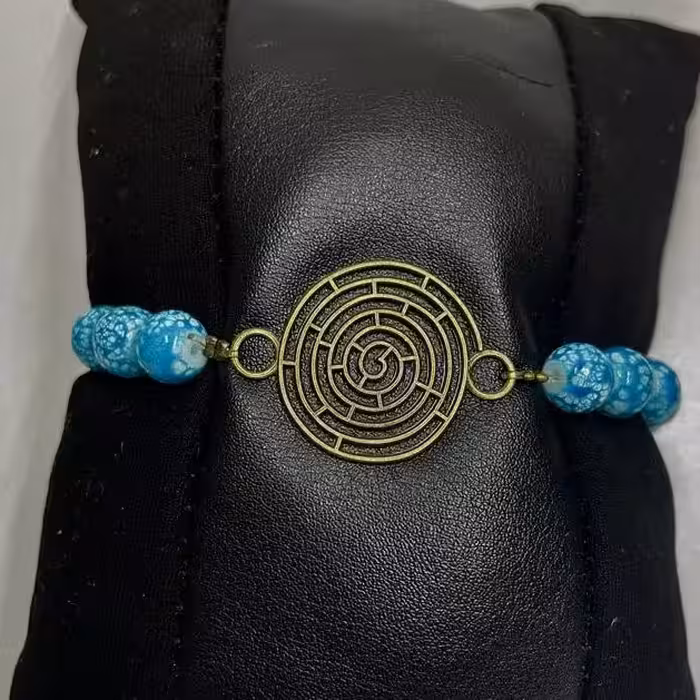 دستبند مدل کشی با مهره های آبرنگی رنگ آبی و خرج کار برنزی طرح ماز 