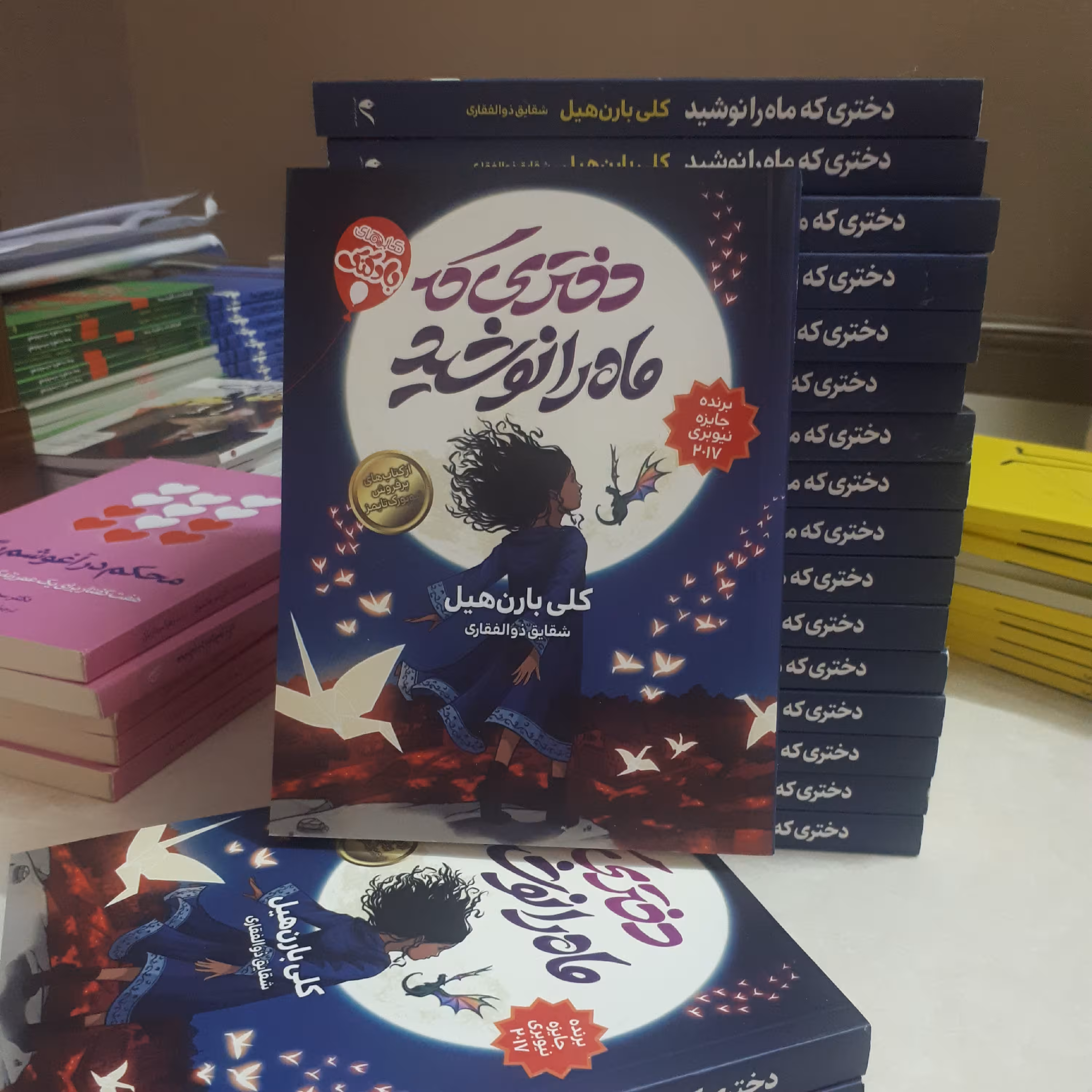 کتاب دختری که ماه را نوشید اثر کلی بارن هیل  ترجمه شقایق ذوالفقاری278صفحه کاغذبالکی