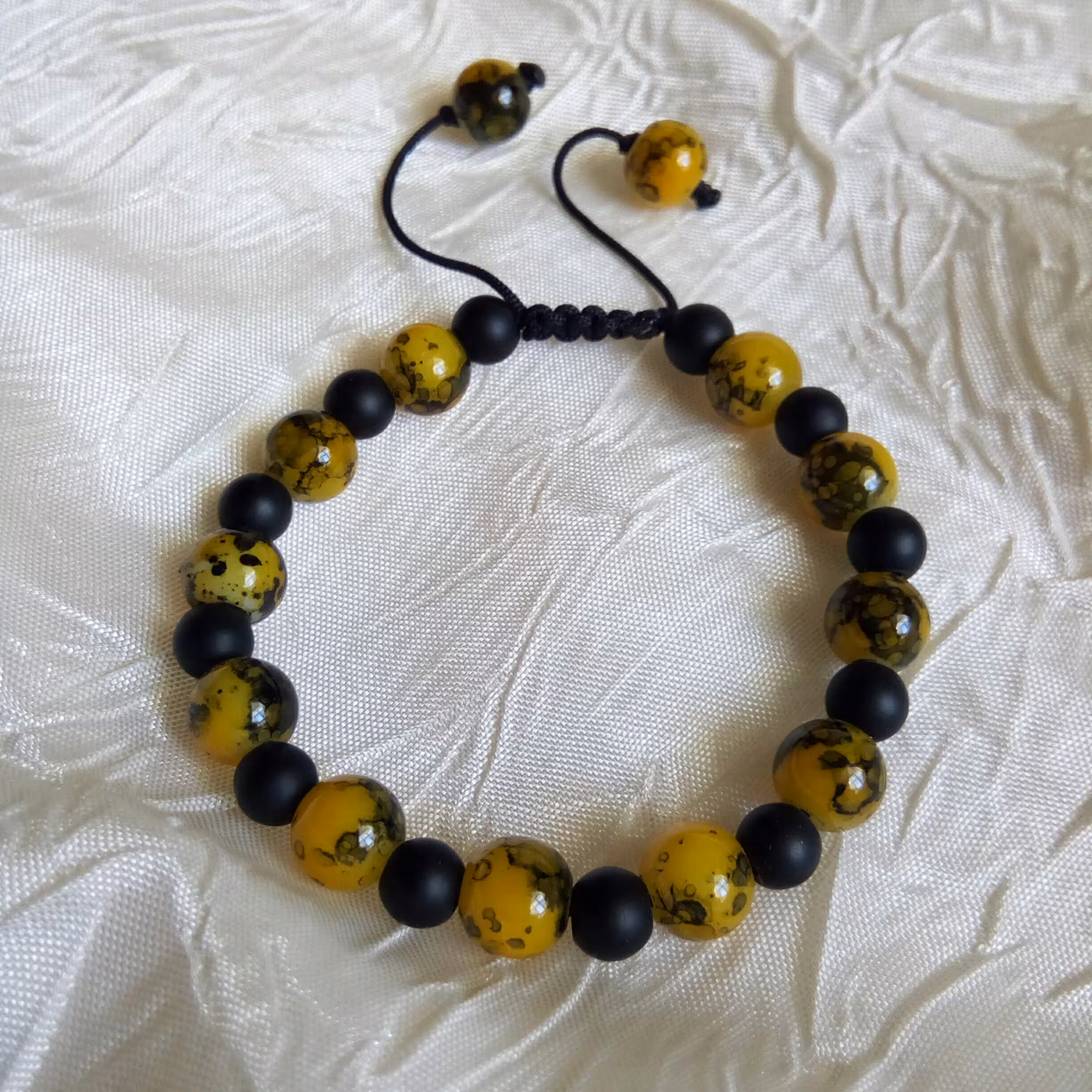 دستبند کشویی تم زنبوری با مهره‌های آبرنگی و اونیکس مشکی و زرد 