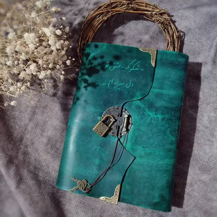 دفتر قفلدار چرمی ، چرم گاوی افکتی کریزی رنگ سبز، 20 در 15, صد برگ کاغذ نخودی رنگ خطدار، حکاکی شده و قفلدار