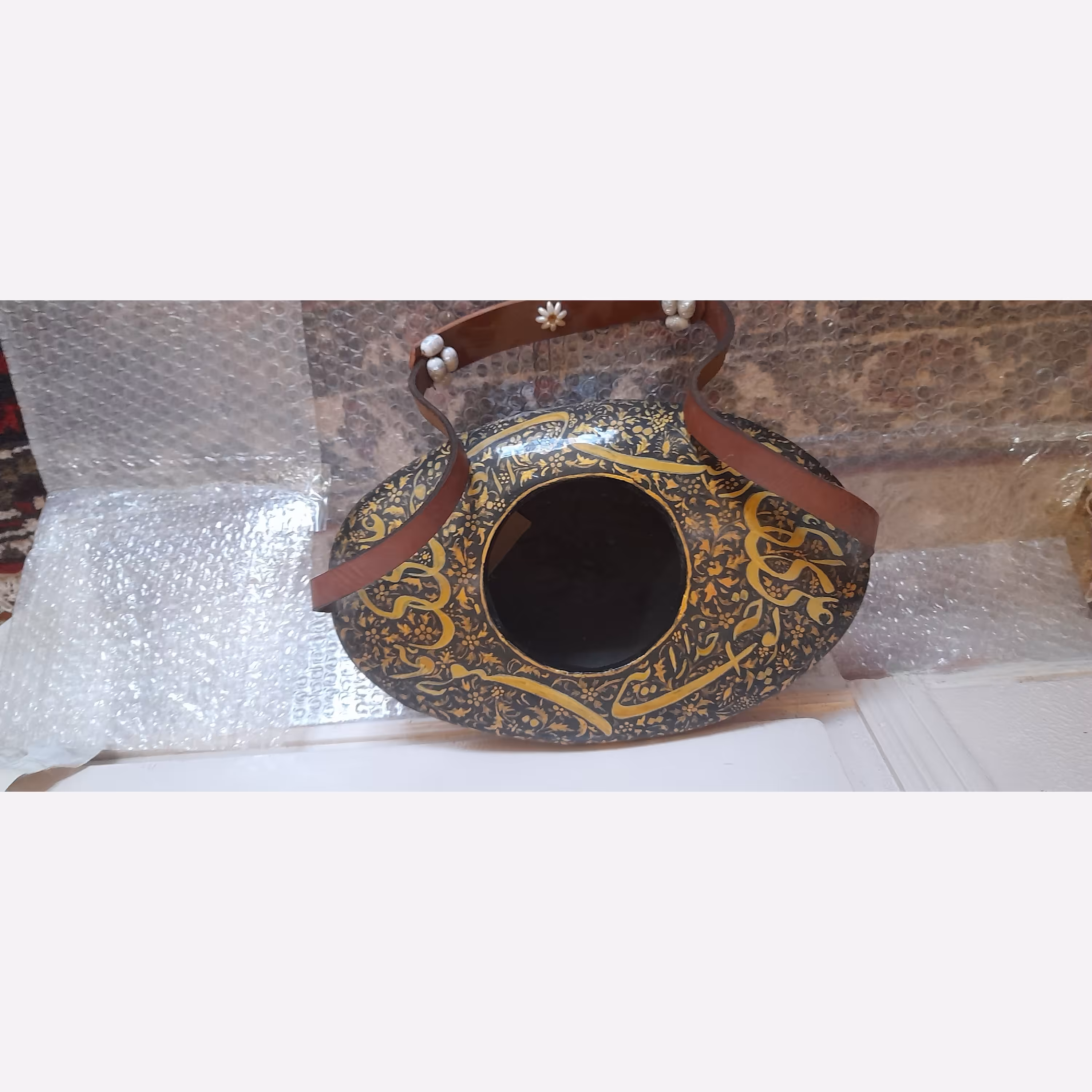 کشکول بانقاشی سنتی لاکی روغنی با رنگ آمیزی گیا هی ومعدنی و با قطر 25 سانتی متر و ارتفاع 20 سانتی متر با دسته چرم  محکم  
