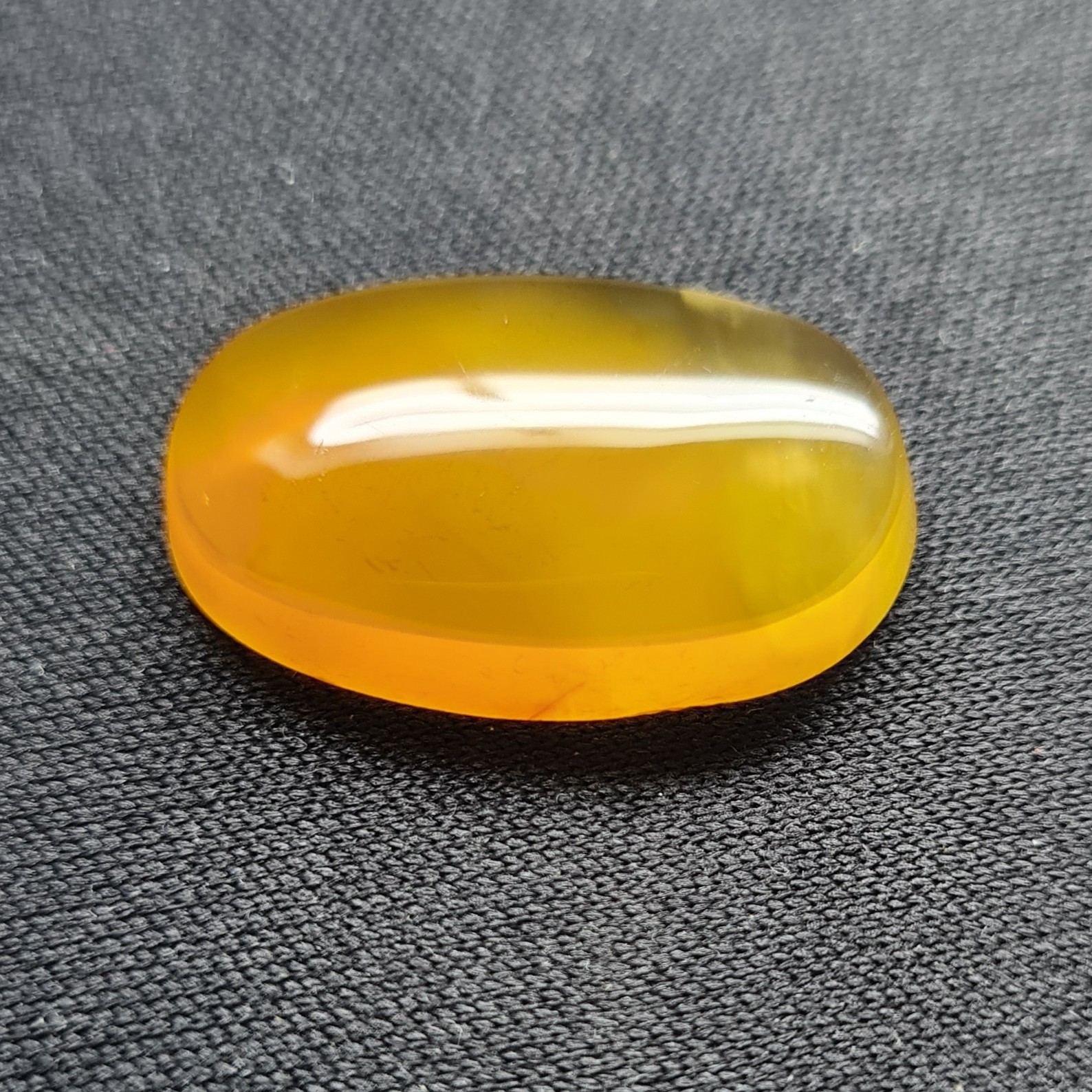نگین عقیق پرتقالب. مشخصات. طول 2.5 سانتی متر. عرض 1.6 سانتی متر. ارتفاع 0.4 سانتی متر.