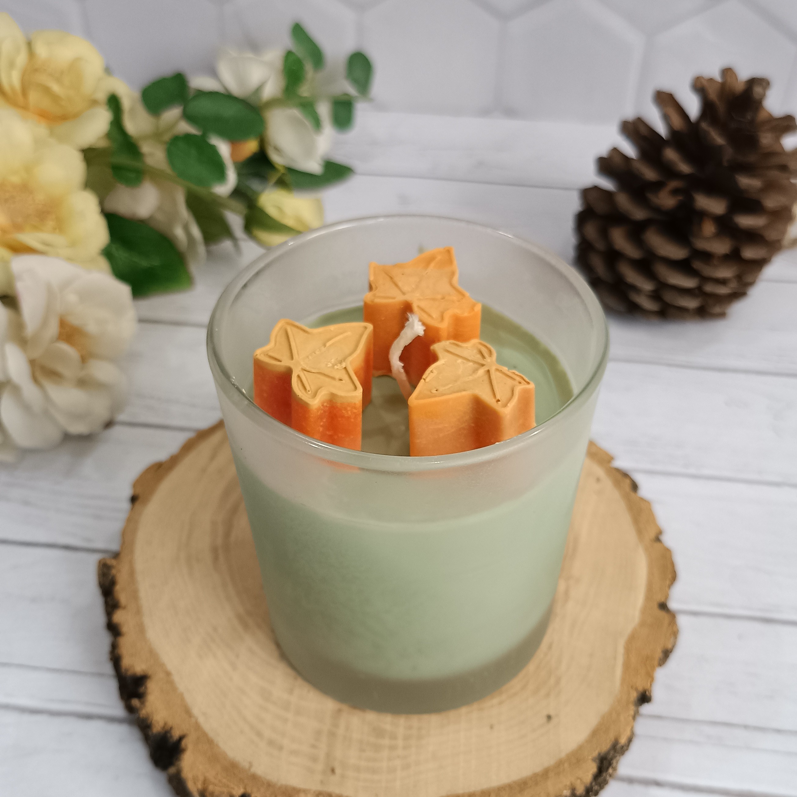 شمع لیوانی مات رنگ شمع سبز مغز پسته ای باتزیین برگ پاییزی نارنجی عطر پرتقال،جنگل وکاج