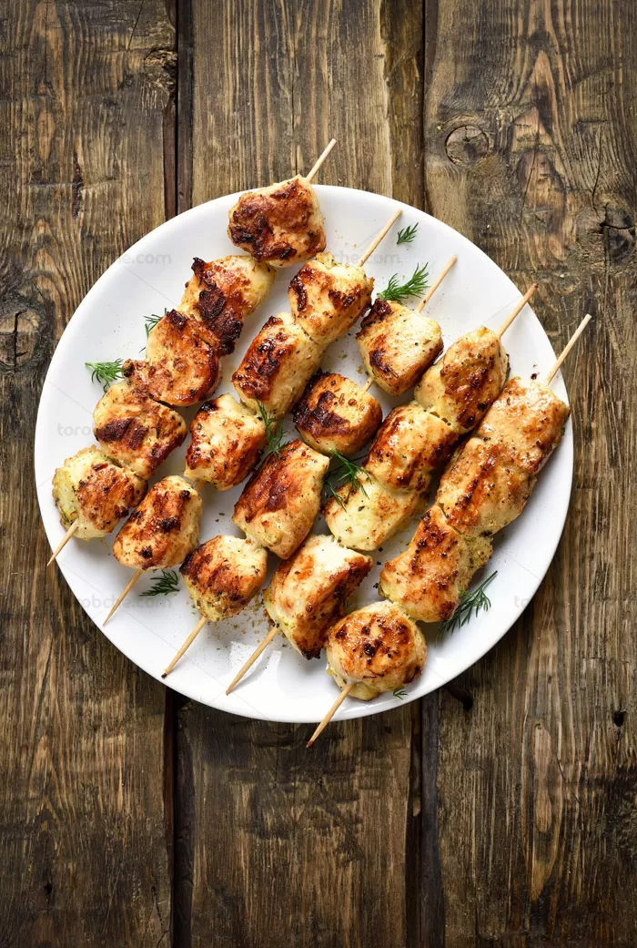 عکس با کیفیت جوجه چینی در بشقاب سفید با زمینه چوبی - گرافیک با طعم تربچه