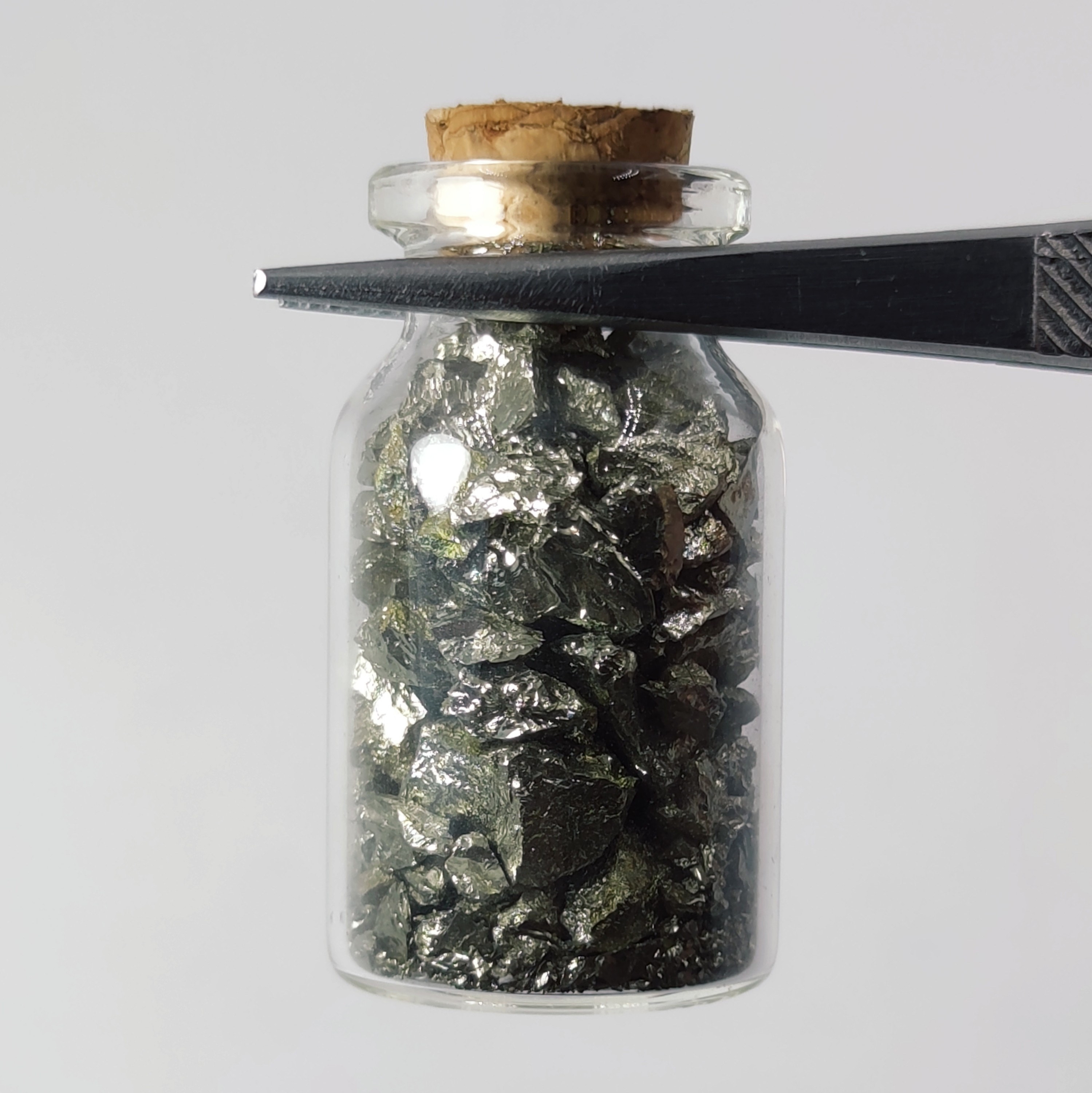 سنگ ریزه های فلز پیریت معدنی در بطری فانتزی 