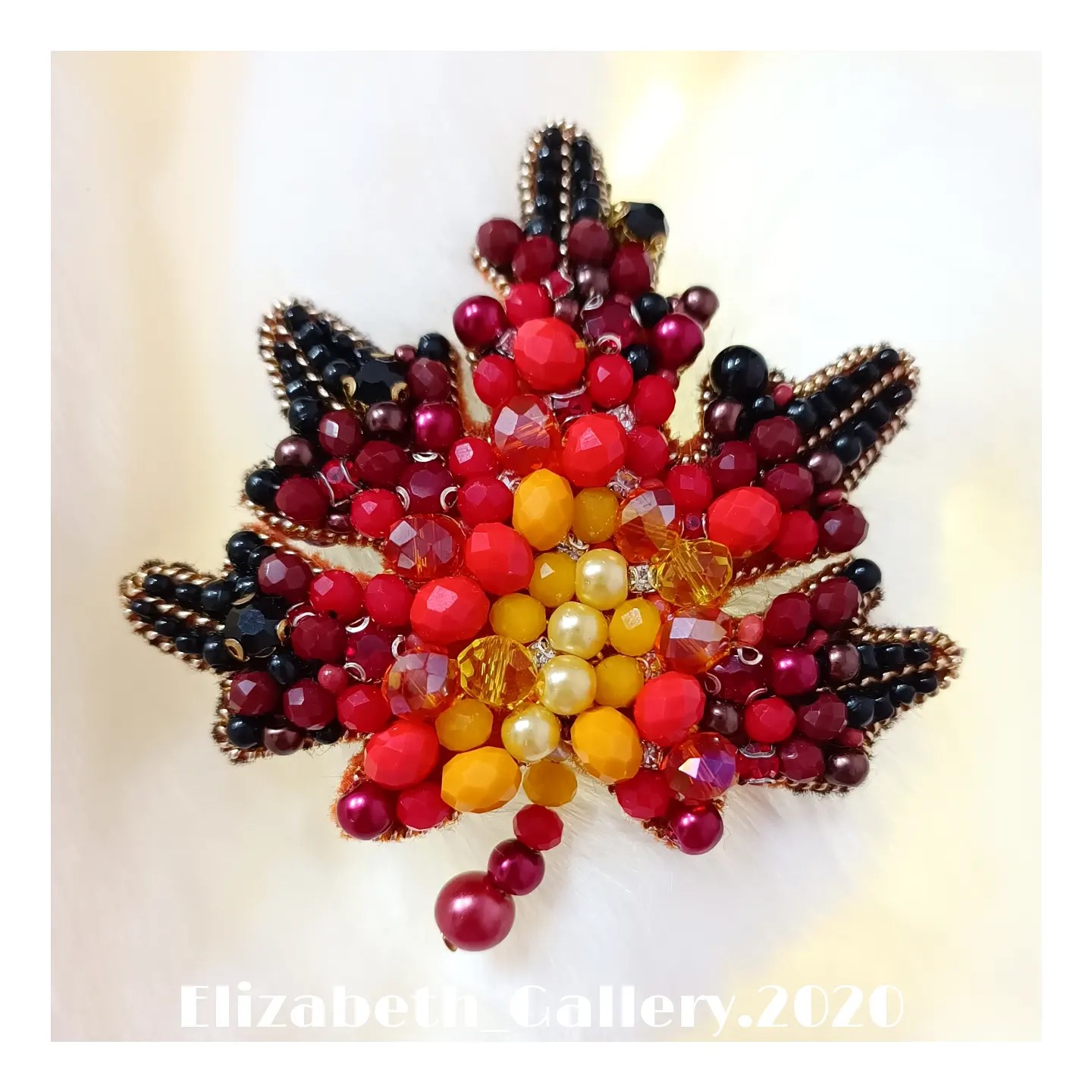 سنجاق سینه جواهر دوزی طرح(برگ پاییزی)که از کریستالهای رنگی، پشت تماماً چرم و به رنگی که در تصویر مشاهده میکنید میباشد.