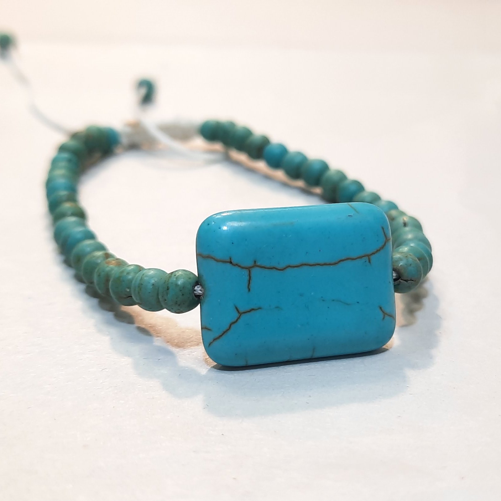 دستبند فری سایز فیروزه فیک و بدلی کد دی178 رنگ بند سفید دارای پللک مستطیل شکل در مرکز