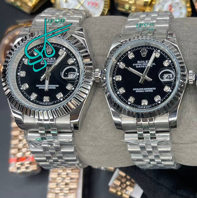 خرید ست ساعت زنانه و مردانه رولکس موتور ژاپن رنگ سیلور صفحه مشکی ایندکس نگینی کیفیت عالی رنگ ثابت سایز بزرگ کد 2116112 - ردگل