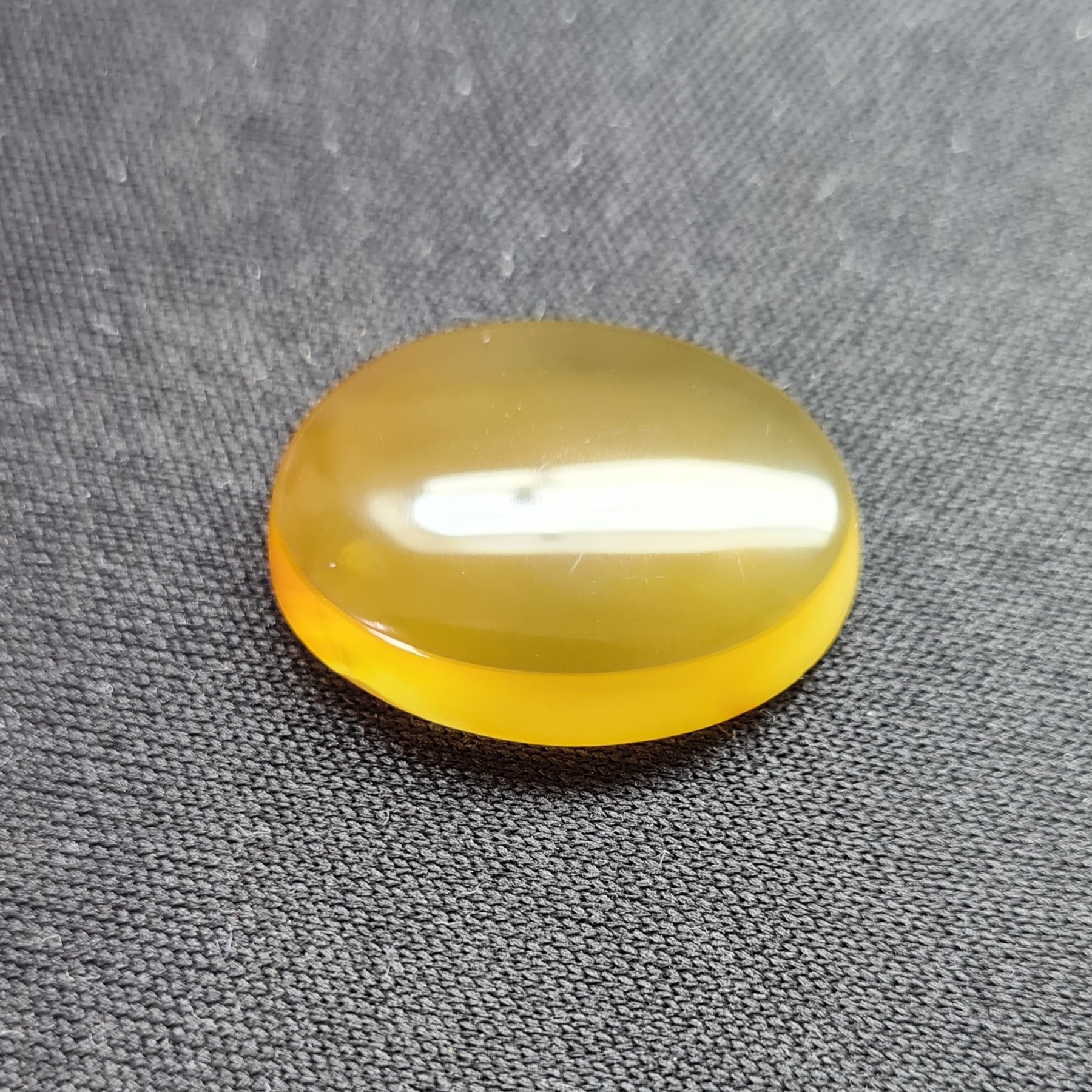 نگین عقیق زرد. مشخصات. طول  2.3 سانتی متر. عرض 1.8 سانتی متر. ارتفاع  0.4 سانتی متر.