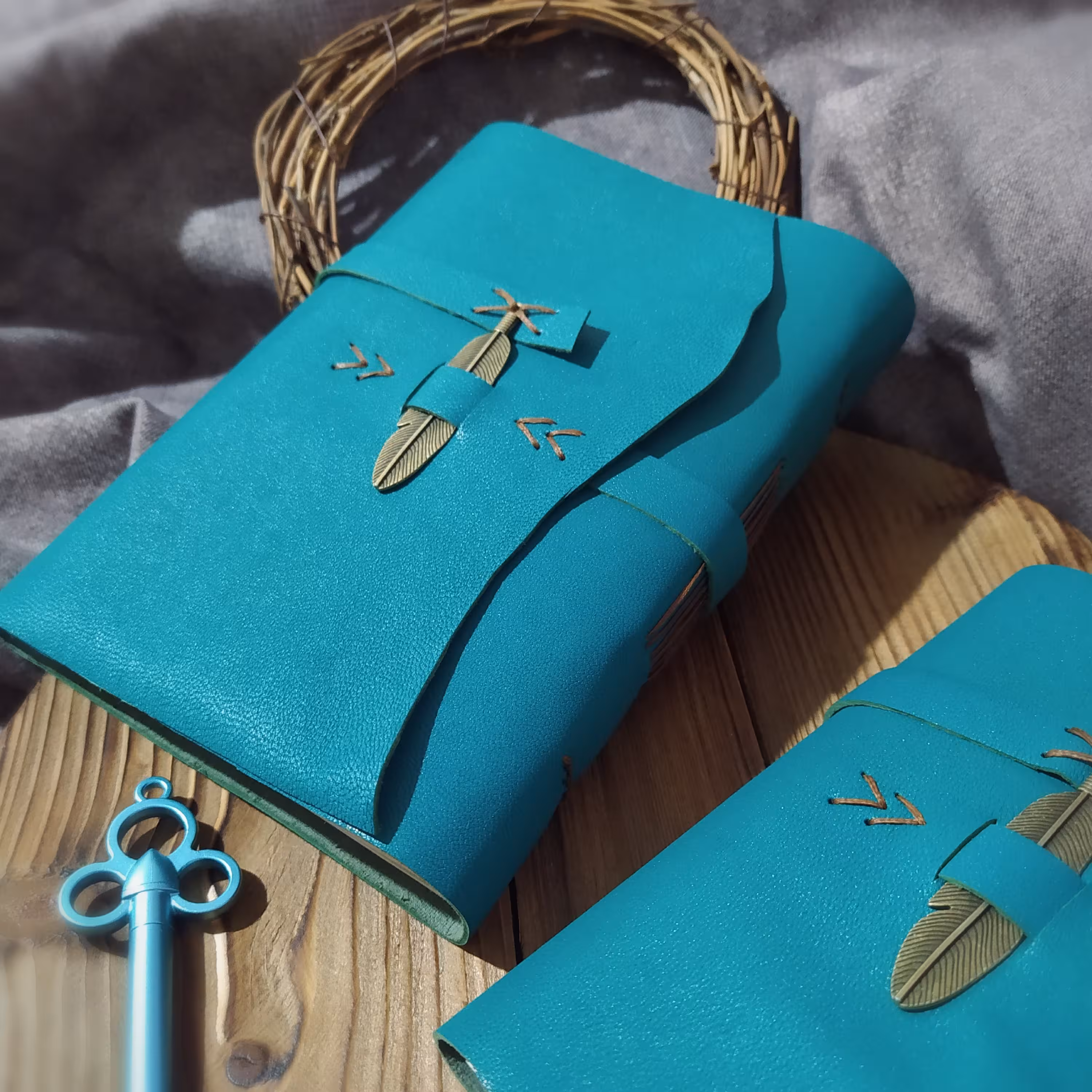 دفتر چرمی فیروزه 19 در 14 چرم بزی فیروزه ای، صد برگ کاغذ نخودی رنگ بدون خط، بست فلزی پر