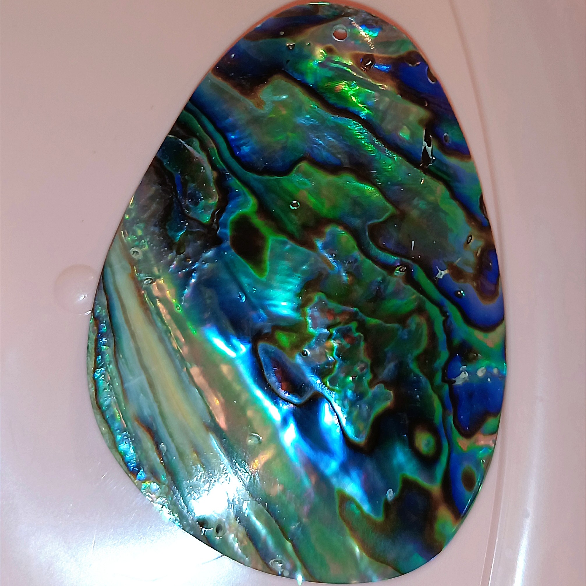 صدف طبیعی آبالون خالص.اغلب آبالونها که در ایرانند روی لاک پلاستیکی شیمیایی میچسبانند که انرژی طبیعیش ازبین میرود