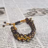 دستبند دو ردیفه (دو رج)
ساخته شده از سنگ اونیکس مشکی آبرنگی و نخ زرد دارای گره کشویی (فری سایز)