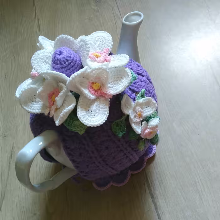 روکش  قوری قلاببافی  طرح گل ارکیده سفید میباشد بدنه دمکنی بنفش است با نخ اکرولیک با کیفیت بافته شده است