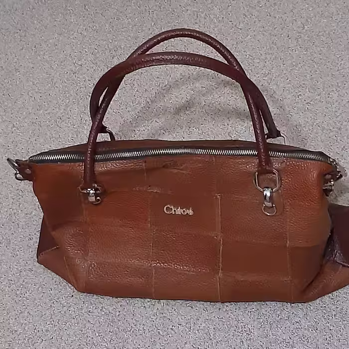 کیف44در26سانتیمتری چرم طبیعی گاو 40تکه مجلسی دست دوز44در26بایراق طلایی یک جیب بیرون وآسترداخلی جیب دار به رنگ عسلی وقهوه
