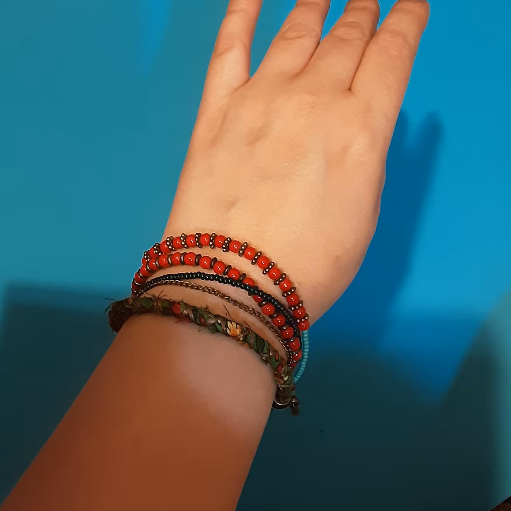 دستبند.5 رج .دارای سنگهای قرمز.فیروزه ای و سبز تیره.1 رج زنجیر برنز و 1 رج بافت سبز .کار شده با برنز