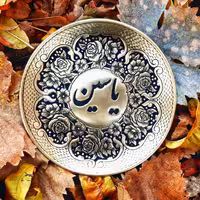 بشقاب قلمزنی شده ی اسم با حاشیه گل و بوته.این بشقاب از جنس برنج است اما شما میتدنید این کار رو روی مس هم سفارش بدین 