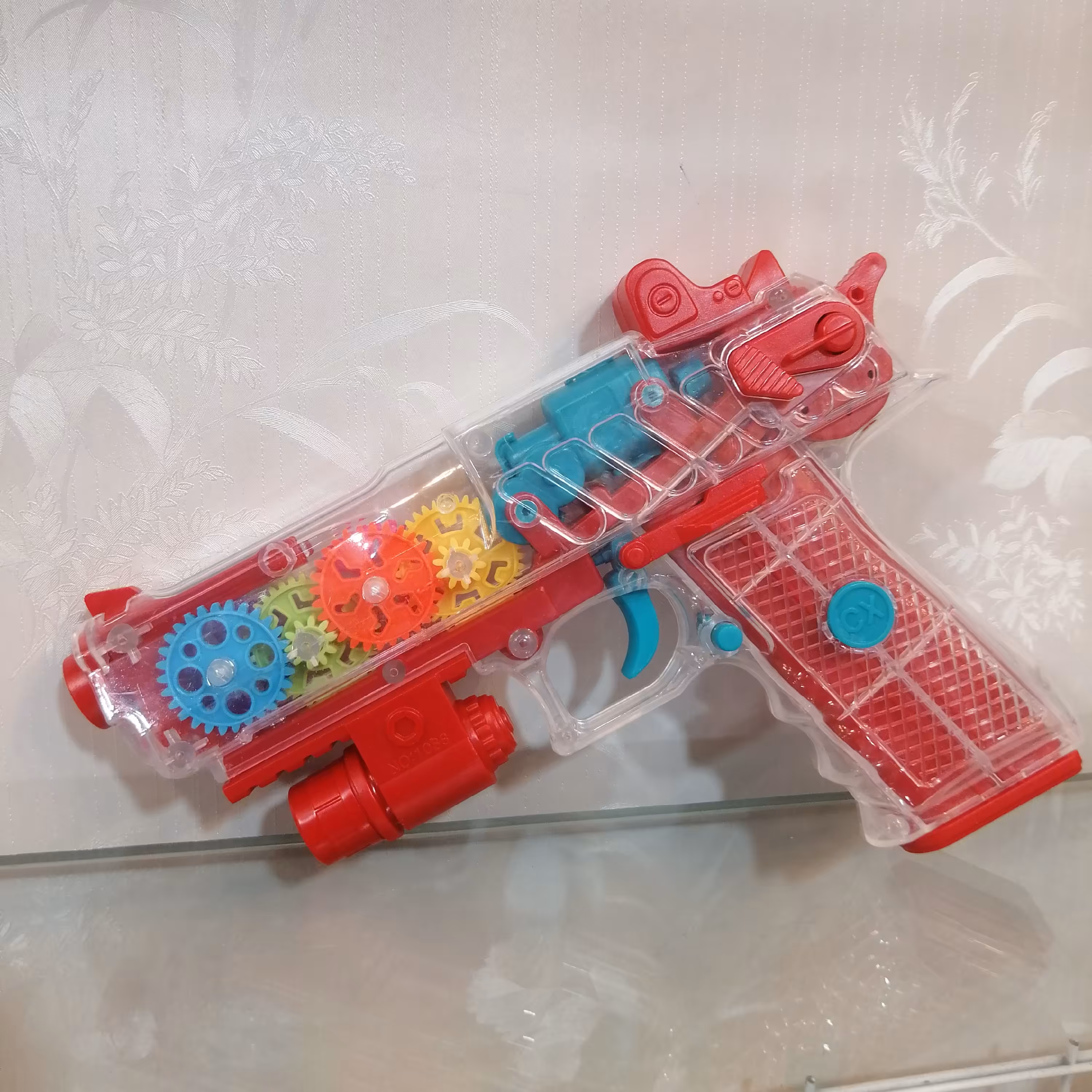 تفنگ اسباب بازی باتری خور چرخ دنده ای رنگ قرمز