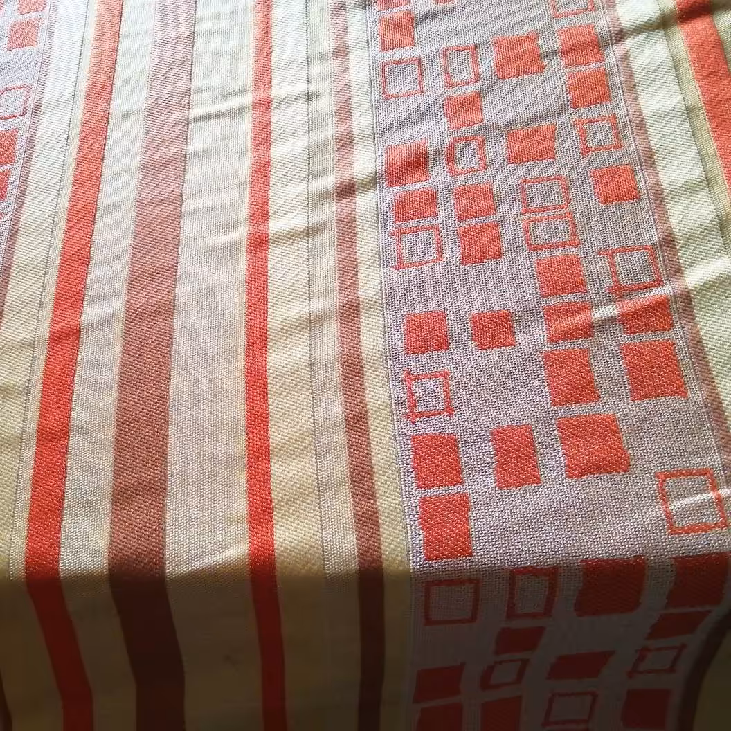 پارچه پرده ای گونی بافت ایرانی عرض 1.5 متر کرم روشن با طرح قرمز (پس کرایه)