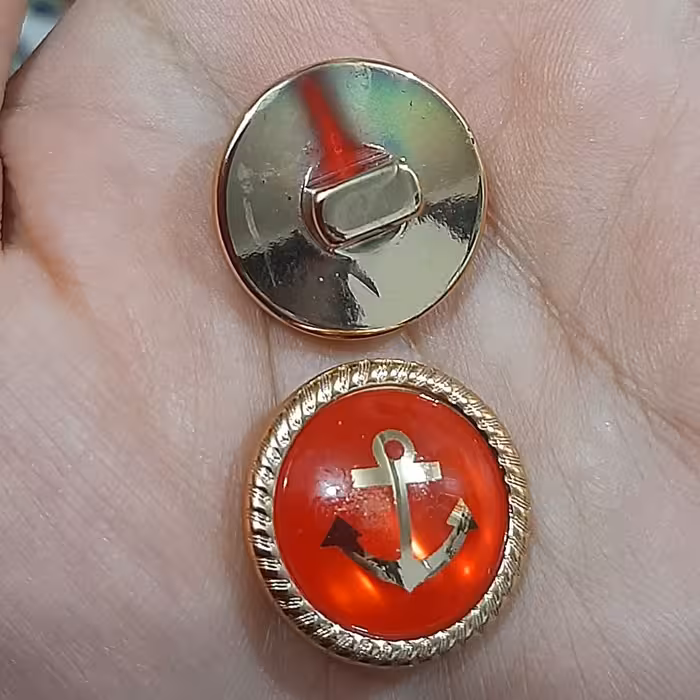 دکمه قرمز طلایی . طرح لنگر . سایز 2 س. 