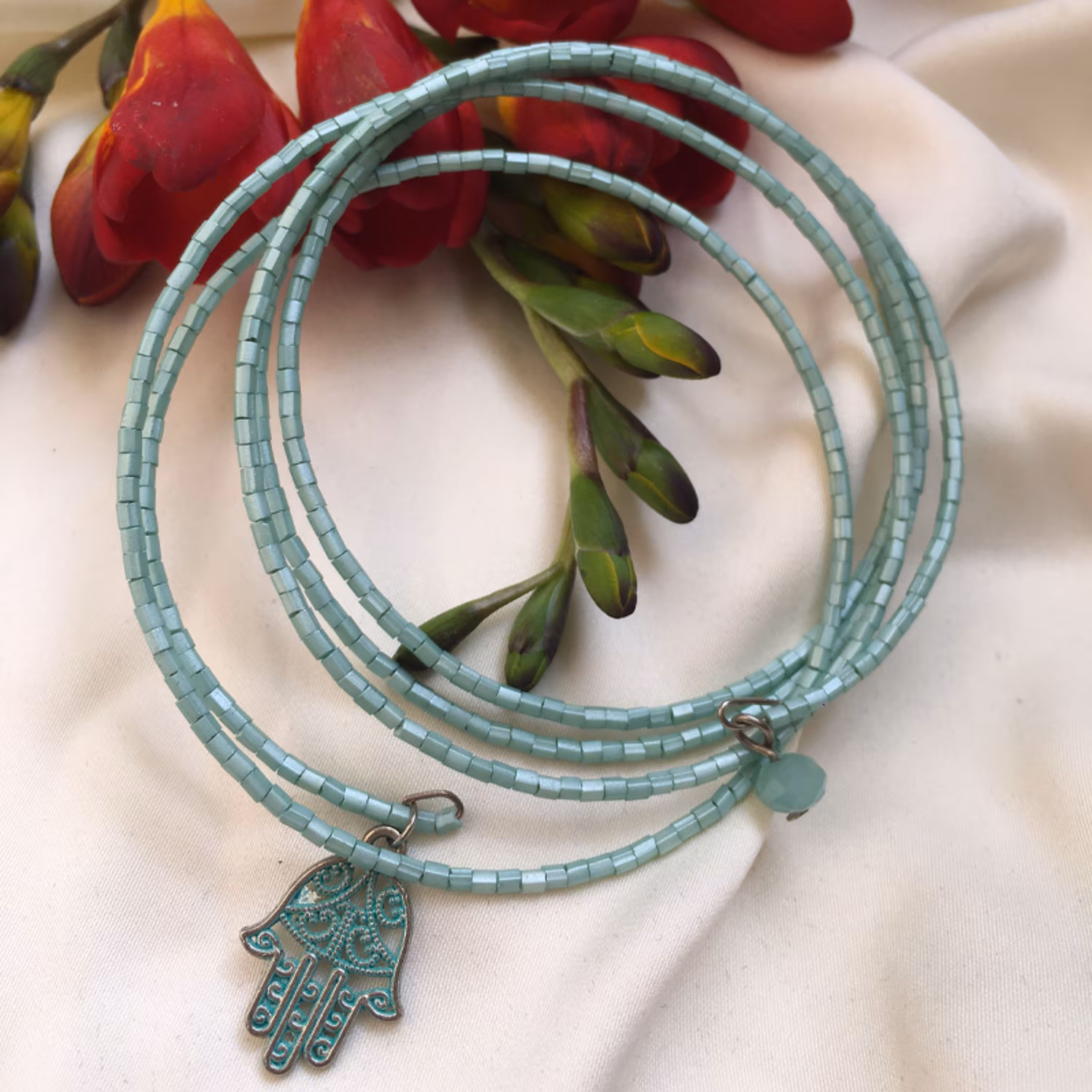 دستبند النگو فنری چند دور زمرد بانو چند دور تلفیقی از منجوق و آویز کریستال و پلاک دست همسا