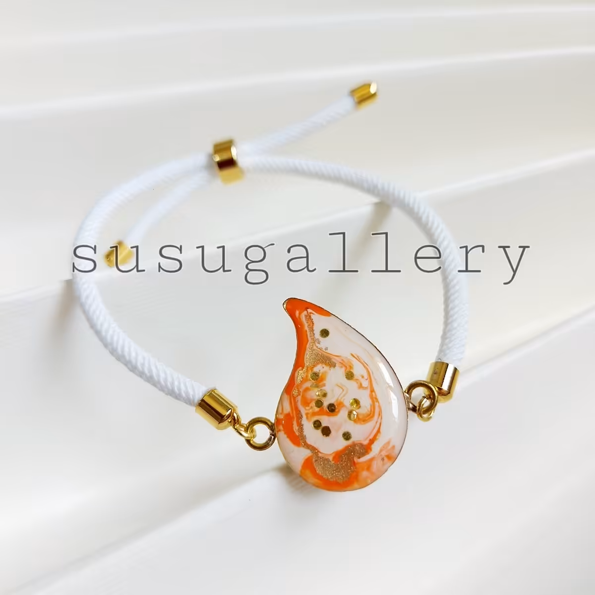 دستبند رزینی بته جقه نارنجی با بند آسانسوری سفید