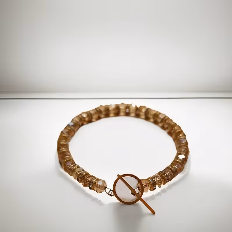 دستبند مهره کریستالی رنگ کرم با قفل تی طلایی | amazonchi