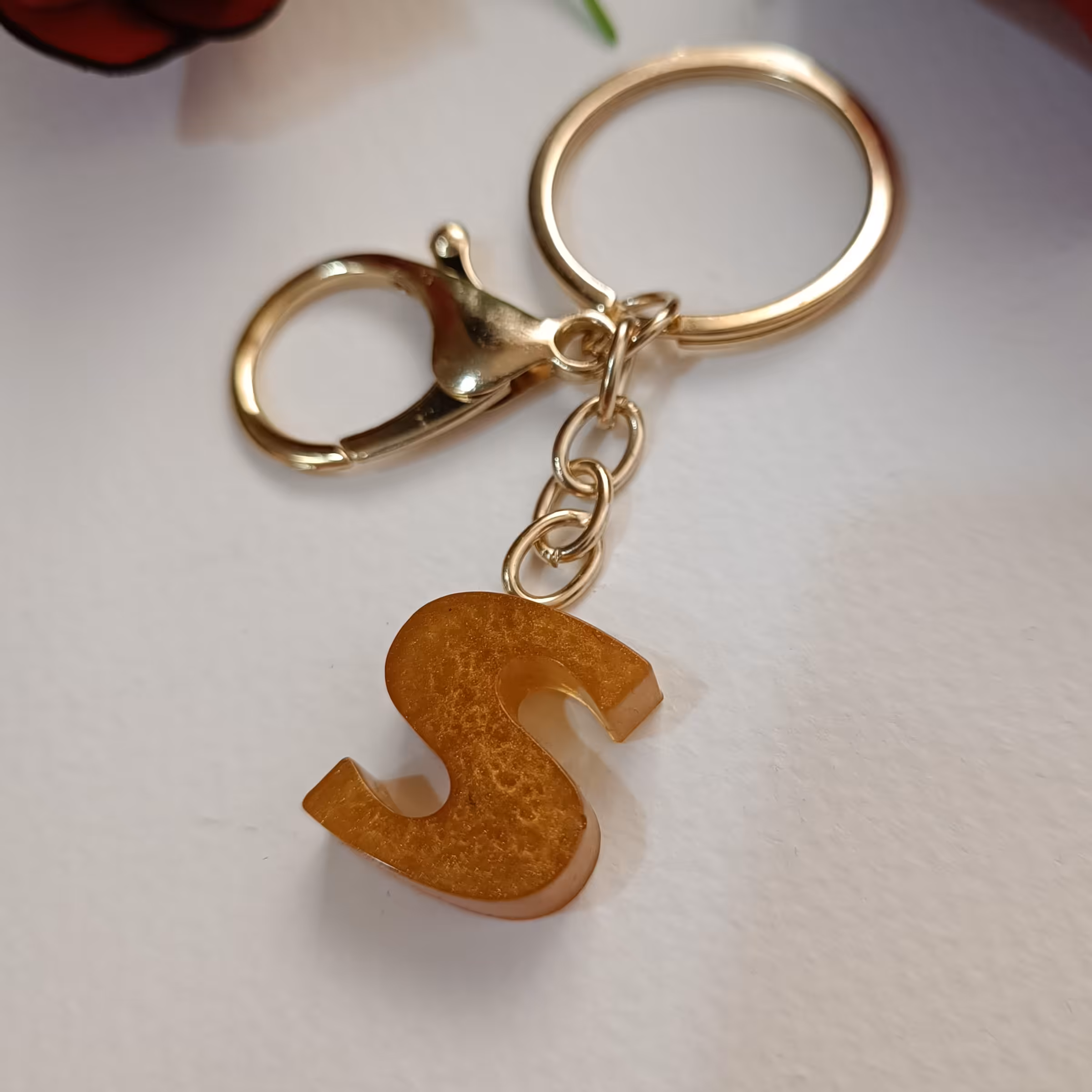 سرکلیدی و آویز کیف حروف رزینی حرف S رنگ عسلی کهربایی رنگ ثابت و ضدحساسیت دارای قفل و حلقه 