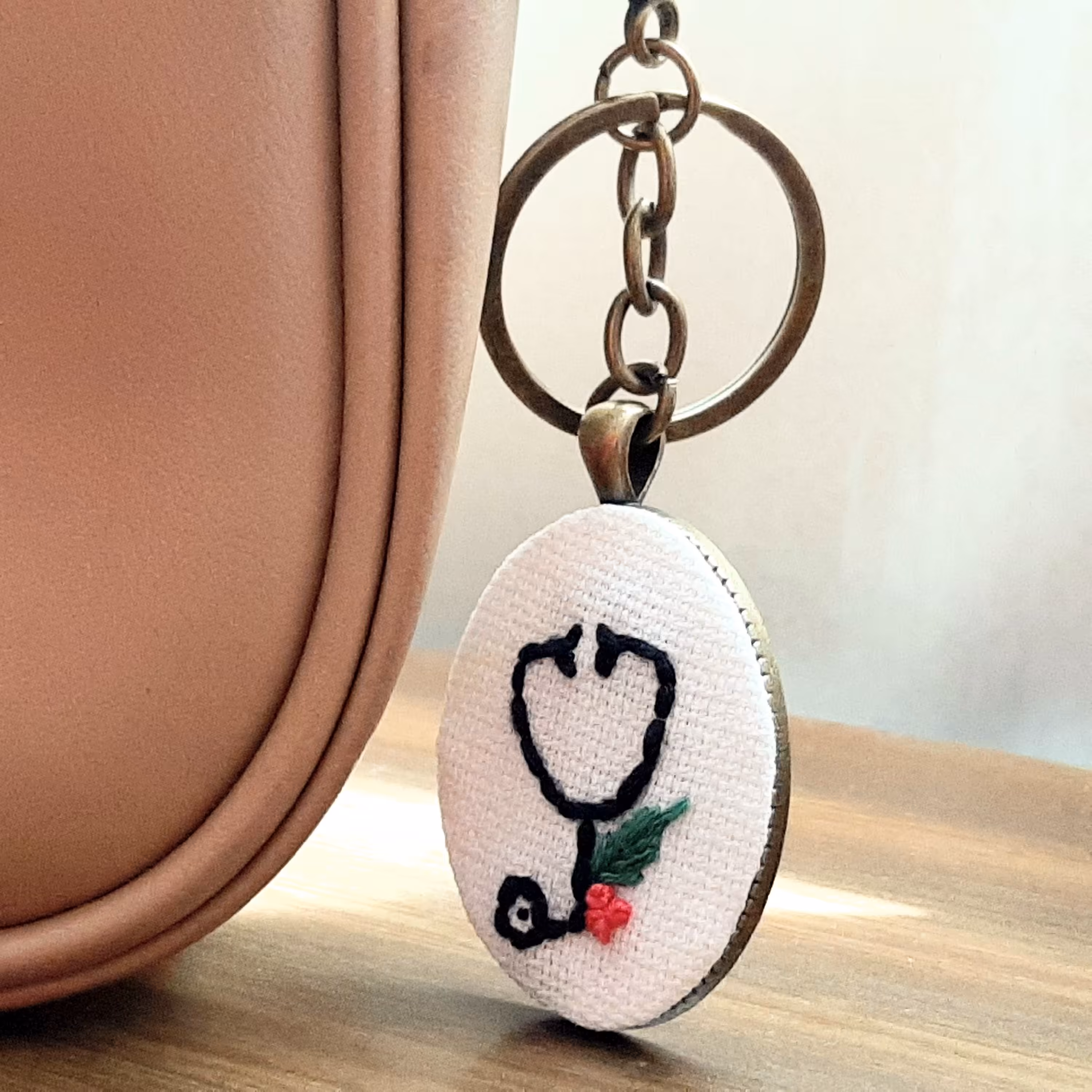 جاسوئیچی و آویز کیف گلدوزی شده، زمینه سفید، طرح گوشی پزشکی