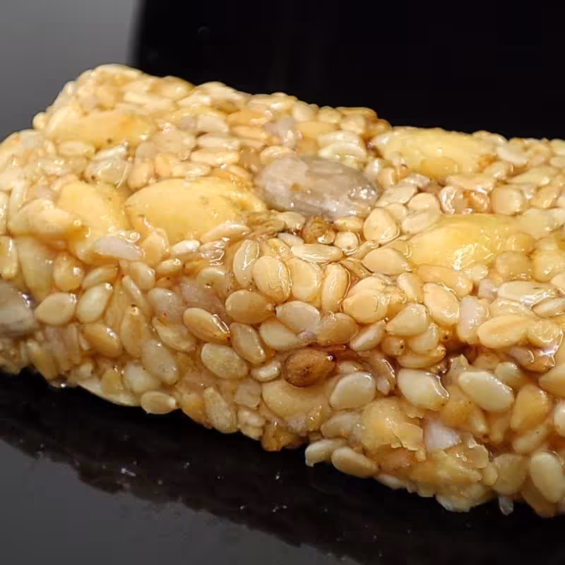 بمب انرژی کنجدعسلی میگون تهیه شده از عسل طبیعی کنجدسفید مغزهای تازه و مقوی